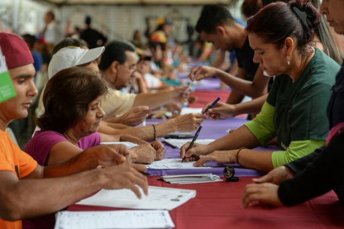 Varias personas marcan sus papeletas en el plebiscito simbólico contra el gobierno de Nicolás Maduro convocado por la oposición, el 16 de julio de 2017 en Caracas © AFP Federico Parra