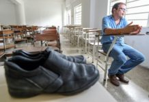 El profesor José Ibarra, de la Universidad Central de Venezuela, en entrevista en un salón de clase el 19 de julio de 2018 en Caracas, donde se aprecia un par de viejos zapatos que no pudo enviar a reparar por el alto costo del arreglo. © AFP Juan BARRETO