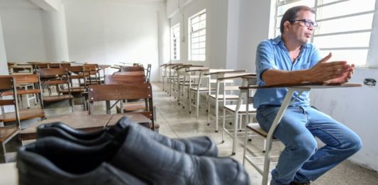 El profesor José Ibarra, de la Universidad Central de Venezuela, en entrevista en un salón de clase el 19 de julio de 2018 en Caracas, donde se aprecia un par de viejos zapatos que no pudo enviar a reparar por el alto costo del arreglo. © AFP Juan BARRETO