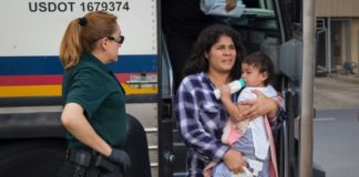 Una mujer baja de un bus con sus bebé luego de ser liberada de un centro de detención en McAllen, Texas, el 17 de junio. © AFP/Archivos Loren ELLIOTT