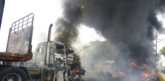 Un hombre vierte gasolina sobre un camión en llamas en la frontera con Venezuela