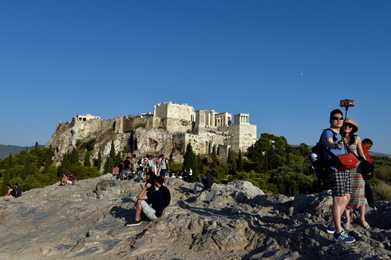 Una danza de palos de selfis en Areopagus Hill frente a la Acrópolis en Atenas