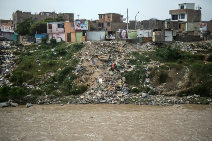 Migrantes venezolanos limpian laderas de río en capital de Perú