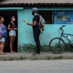 Maestro reparte deberes en bicicleta a alumnos de una favela de Brasil