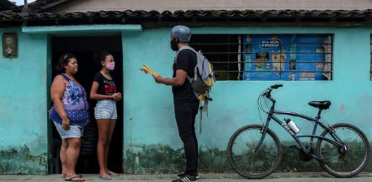 Maestro reparte deberes en bicicleta a alumnos de una favela de Brasil