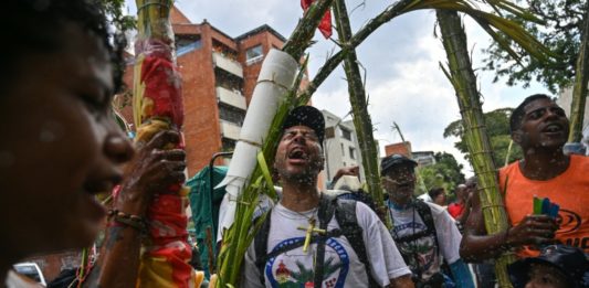 “Palmeros bajan de una montaña en Caracas para el Domingo de Ramos