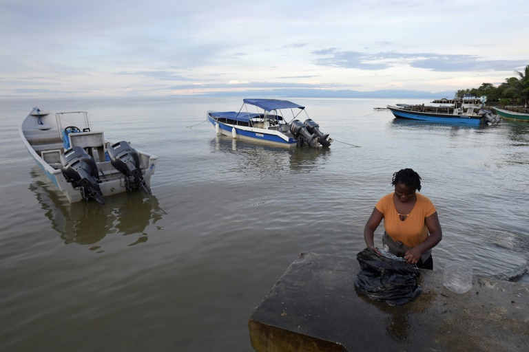 Migrantes rumbo a EEUU esperan transporte en un puerto de Colombia