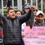 Pescadores lanzan peces negros frente a las oficinas de Repsol en Lima