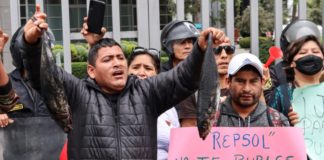 Pescadores lanzan peces negros frente a las oficinas de Repsol en Lima