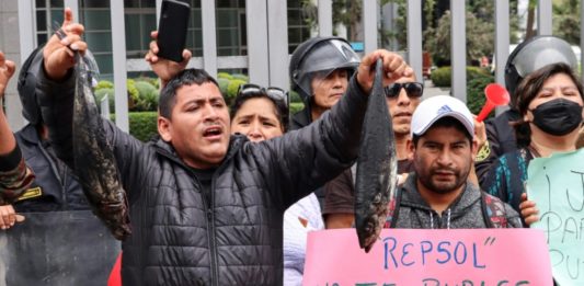 Pescadores lanzan peces negros frente a las oficinas de Repsol en Lima