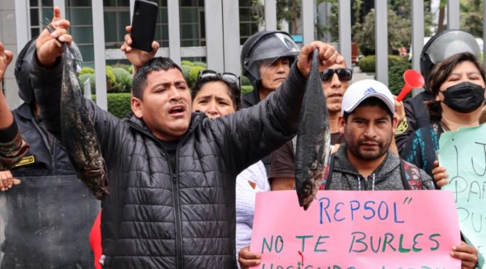 Pescadores lanzan peces negros frente a las oficinas de Repsol en Lima